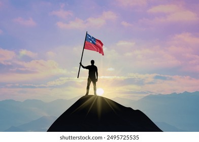 Waving flag of Samoa at the top of a mountain summit against sunset or sunrise. Samoa flag for Independence Day. - Powered by Shutterstock