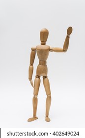 Waving Goodbye/Person Represented By A Wooden Dummy Waving His Hand As A Sign Of Saying Good Bye To Someone Leaving.