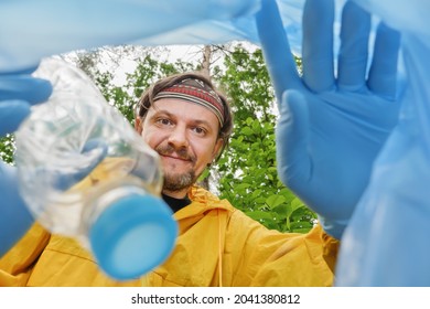 Waving Hello Invites You To Join Cleaning Park. Picking Up Garbage Plastic Bottle. Volunteer Cleaning Forest View From Inside A Plastic Bag. Volunteer Collecting Litter Picking Up Trash In Garbage Bag