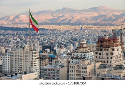 Waving Iran Flag Above Skyline Of Tehran At Sunset.