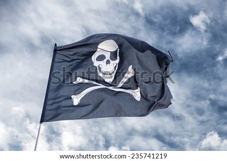 waving pirate flag jolly roger on sky background