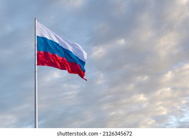 Waving Russian flag against a blue sky with clouds and empty space for text. Room for text. National flag of the Russian Federation. - Shutterstock ID 2126345672
