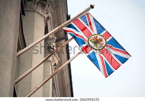 Waving Union Jack flag with the Royal Coat of\
Arms, the official coat of arms of the British monarch, used by\
British Embassies\
overseas