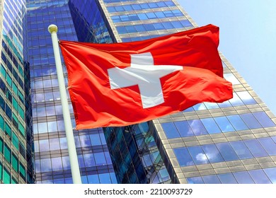 Waving in the wind flag Switzerland on the background of a modern building. Concept of politics, business and tourism in Switzerland