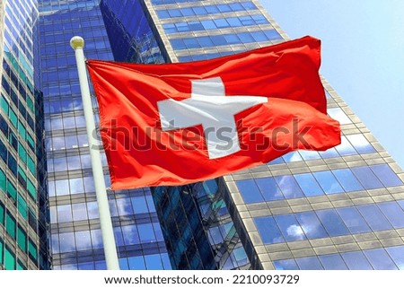 Waving in the wind flag Switzerland on the background of a modern building. Concept of politics, business and tourism in Switzerland