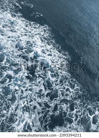 Wavy and foamy blue sea water abstract background and wallpaper