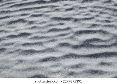 Wavy snow illuminated by the morning sun in spring closeup - Shutterstock ID 2277875391
