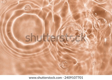 Wavy solar circles, bubbles on the water. Light peachy textured background. The perfect solution for any design. Close-up, selective focus. Color of the year 2024