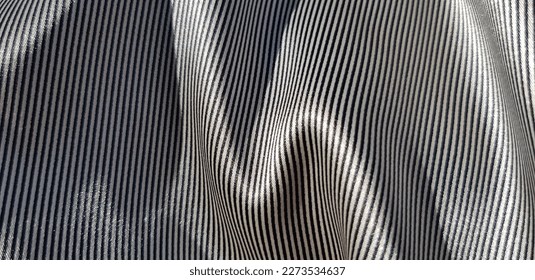 Wavy surface of silk fabric with striped black and white print,
				with zigzag fold (macro, texture).
				