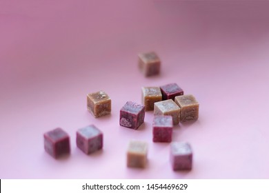 Wax Aroma Purple Beige And Brown Cubes Candles On Pink Background, Copy Space, Closed Up