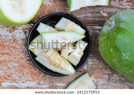Wax gourd or ash gourd sliced in a plate on wooden background top view 