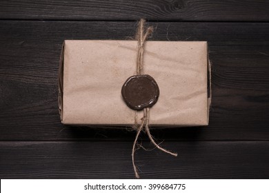 Wax Seal On Vintage Box. Retro Parcel With Security Wax Seal On Black Wooden Table With Rough Texture. Top View, Copy Space. View From Above.