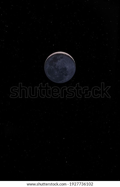 Waxing crescent moon with a night sky stars\
background. Amazing view of the tiny moon surface illuminated by\
the sun and the dark side of the moon. Dramatical thin line cut out\
in the starry nighsky