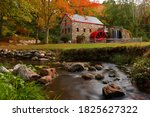 The Wayside Inn Grist Mill with water wheel and cascade water fall in Autumn, Sudbury Massachusetts USA