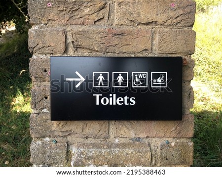 WC sign icon. Toilet symbol. Washroom sign on black background attached to brick wall