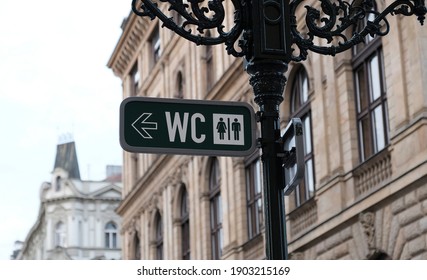 WC sign, logo of public toilets in the street against building background. For female, male. Public toilet sign on vintage street light pillar. Street lamp with wc symbols in downtown Prague.  - Shutterstock ID 1903215169
