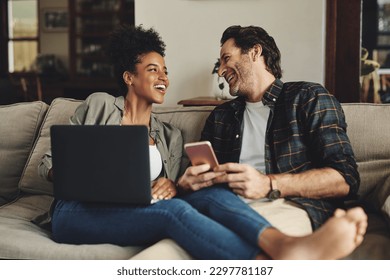 We always have the best of times together. a happy young couple using a laptop and cellphone while relaxing on a couch home. - Powered by Shutterstock