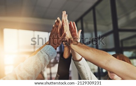 We always win. Shot of a group of colleagues giving each other a high five.