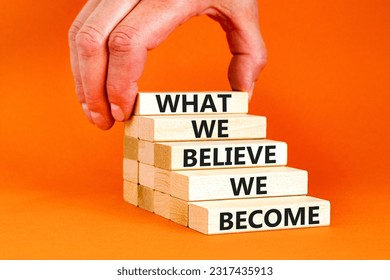 We become or believe symbol. Concept word What we believe We become on wooden block. Beautiful orange table orange background. Businessman hand. Business we become or believe concept. Copy space.