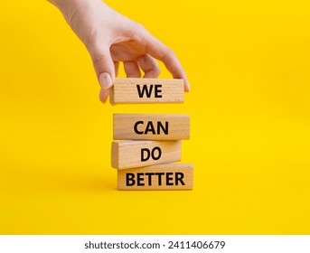 We Can Do Better symbol. Concept words We Can Do Better on wooden blocks. Beautiful yellow background. Businessman hand. Business and We Can Do Better concept. Copy space.