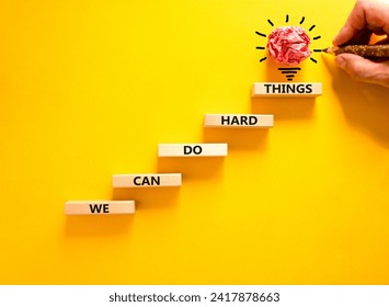 We can do hard things symbol. Concept words We can do hard things on wooden blocks. Beautiful yellow table yellow background. Businessman hand. Business, we can do hard things concept. Copy space.