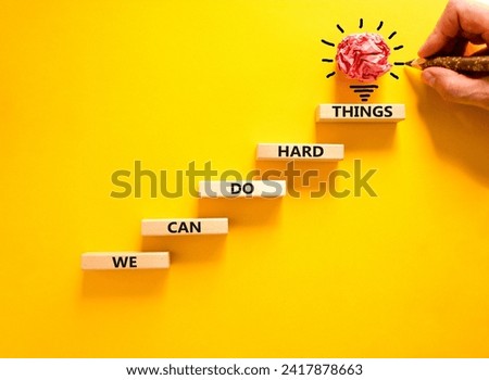 We can do hard things symbol. Concept words We can do hard things on wooden blocks. Beautiful yellow table yellow background. Businessman hand. Business, we can do hard things concept. Copy space.