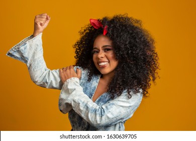 We Can Do It. Woman's Fist Of Female Power. Woman Victim Of Racism. Abuse At Work. The Feminine Power. Female Empowerment. The Strength Of Women. Yellow Background.