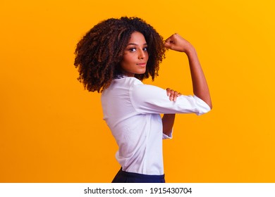 We Can Do It. Woman's Fist Of Female Power. Woman Victim Of Racism. Abuse At Work. The Feminine Power. Female Empowerment. The Strength Of Women. Yellow Background.
