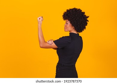 We Can Do It. Woman's Fist Of Female Power. Woman Victim Of Racism. Abuse At Work. The Feminine Power. Female Empowerment. The Strength Of Women. Yellow Background.