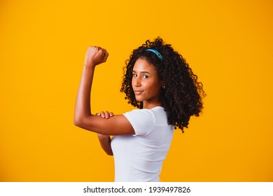 We Can Do It. Woman's Fist Of Female Power. Woman Victim Of Racism. Abuse At Work. The Feminine Power. Female Empowerment. The Strength Of Women. Yellow Background.