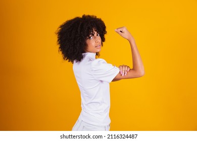 We can do it. Woman's fist of female power. Woman victim of racism. Abuse at work. The feminine power. Female empowerment. The strength of women. Yellow background.