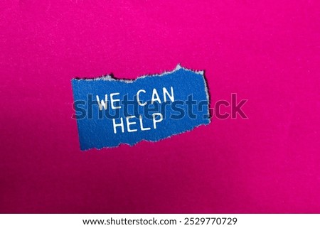 We can help message written on ripped blue torn paper piece on pink background. Conceptual we can help symbol. Copy space.