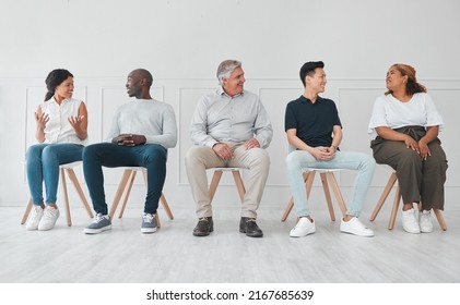 We Can Learn A Lot By Listening To Each Others Stories. Shot Of A Diverse Group Of People Talking To Each Other While Sitting In Line Against A White Background.