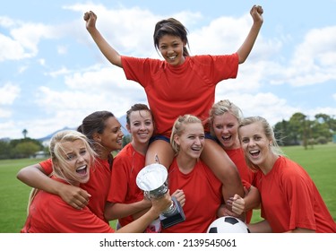 We Are The Champions. Portrait Of An All-girls Soccer Team Raising Their Captain In Triumph.