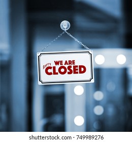 WE ARE CLOSED sign board through the glass of store window. Filtered image. - Shutterstock ID 749989276
