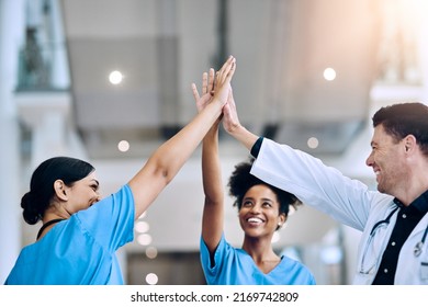 We Did It Together. Shot Of A Diverse Team Of Doctors Giving Each Other A High Five In A Hospital.