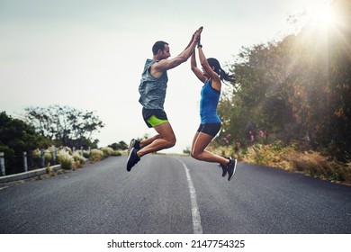 We Did It And We Did It Together. Shot Of A Young Attractive Couple Training For A Marathon Outdoors.