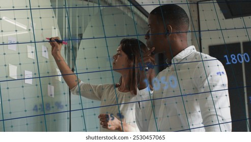 We are a diverse group of businesspeople writing on a whiteboard in a modern office. we are engaged in business and finance, processing data and digital interface concepts. - Powered by Shutterstock