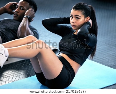 We dont do lunch dates, we do crunch dates. Shot of a young man and woman doing sit ups in a gym.