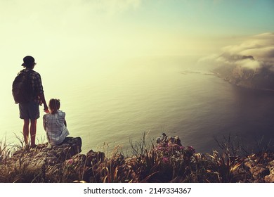 We dont need more than love and a view. Rearview shot of an unidentifiable young couple admiring the view from a mountain peak together.
