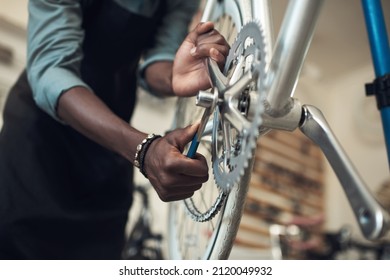 We dont want this falling off. Shot of an unrecognizable man standing alone in his shop and repairing a bicycle wheel.