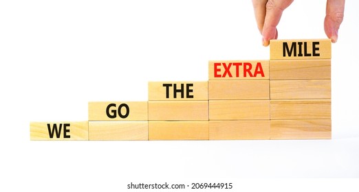 We go the extra mile symbol. Wooden blocks with words We go the extra mile. Beautiful white background, copy space. Businessman hand. Business, we go the extra mile concept. - Shutterstock ID 2069444915