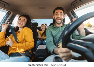 We are going on vacation. Happy family of three driving in their automobile, dancing to music and singing favorite song, enjoying travelling by car