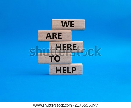 We are here to help symbol. Concept words we are here to help on wooden blocks. Beautiful blue background. Business and we are here to help concept. Copy space.