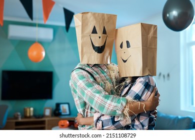 We Love Being Silly Together. Shot Of A Young Couple With Paper Bags Over Their Heads At Home.