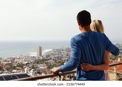 We love our new place. A happy couple standing on a balcony looking over the view. - Powered by Shutterstock