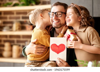 We love you  dad  Young happy father getting congratulations Fathers Day from two excited kids at home  son   daughter  smiling children giving daddy handmade postcard   wrapped gift box