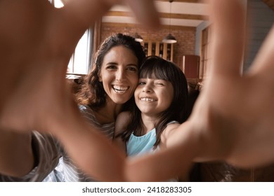 We love you. Latin mom and preteen daughter video bloggers influencers shoot content unite fingers in heart sign grateful for attention. Bonding mother and kid shoot selfie look at camera express love - Powered by Shutterstock