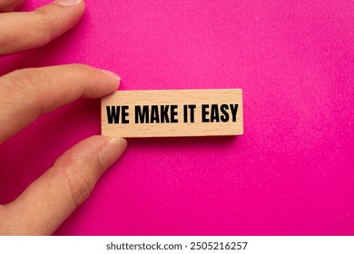 We make it easy message written on wooden block with pink background. Conceptual we make it easy symbol. Copy space.