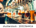 We meet oktoberfest. Hand of bartender pouring a large lager beer in tap. Pouring beer for client. Side view of young bartender pouring beer while standing at the bar counter